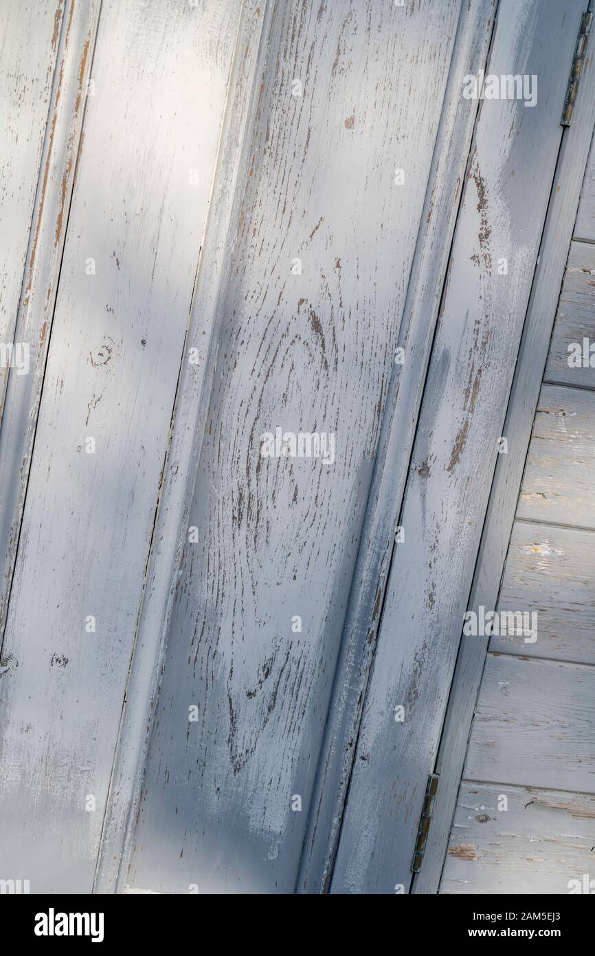 La peinture abîmé s'écaille d'une vieille porte en bois.Peinture écaillée, craquelures de peinture, vieille peinture, vieille porte décolorée par le temps. Banque D'Images