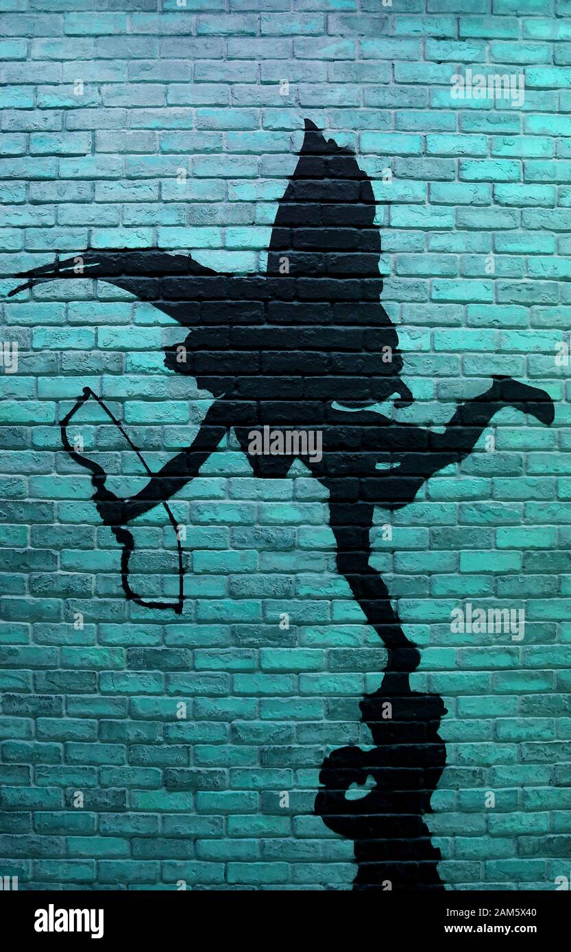 Image verticale du mur bleu turquoise de brique avec la peinture de la silhouette de cupid Banque D'Images