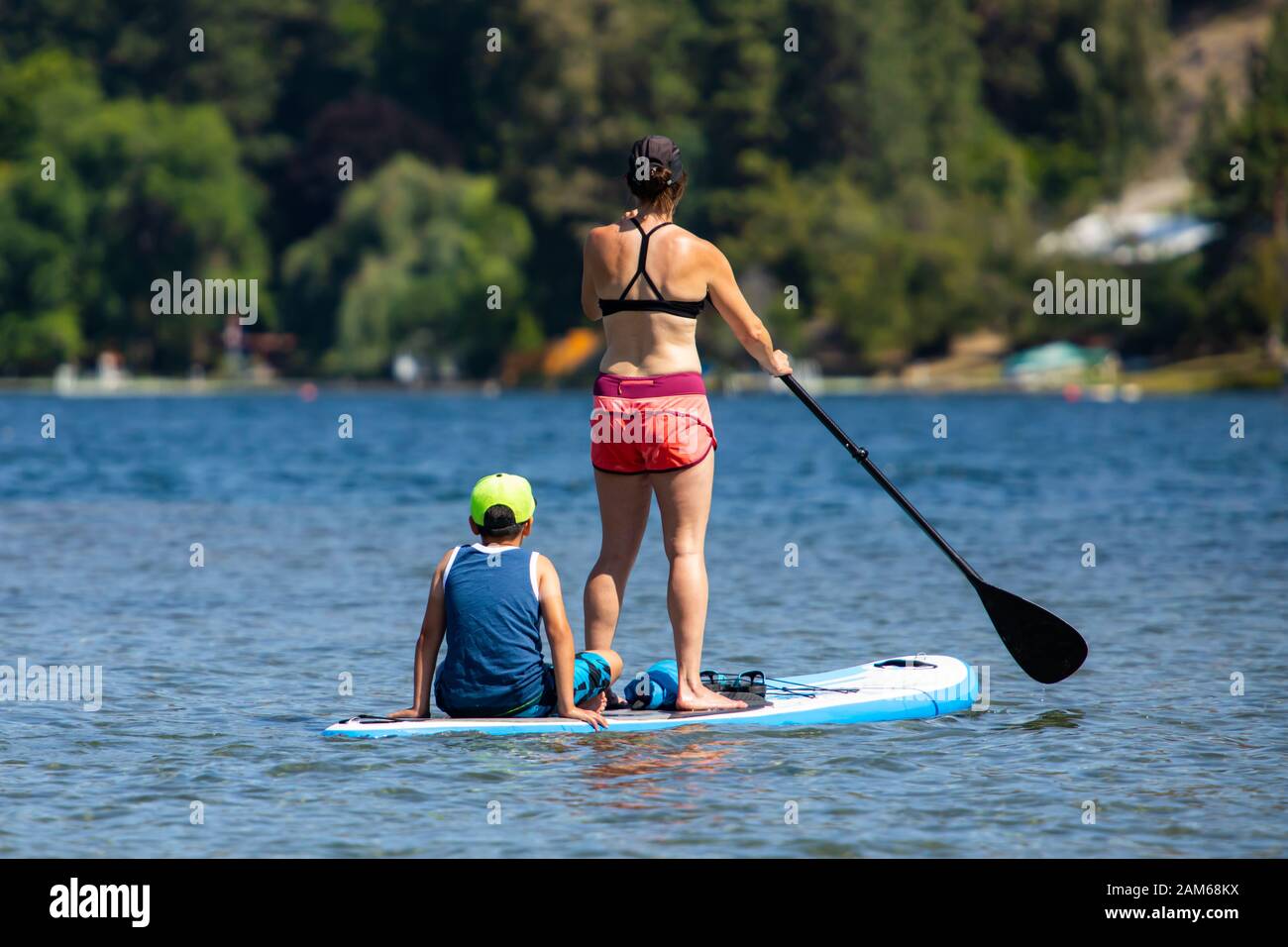 Vue de retour à la femme athlétique avec enfant pendant le paddboard dans  les vêtements de sport. Jeune maman enseignant son paddle board. Vacances  d'été actives Photo Stock - Alamy
