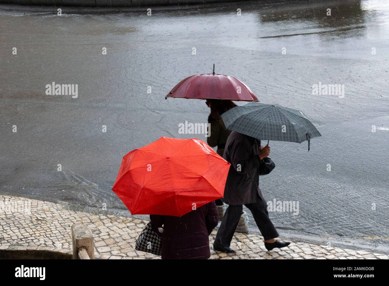 Les piétons essaient de rester au sec sous de fortes pluies à Coimbra Portugal Banque D'Images