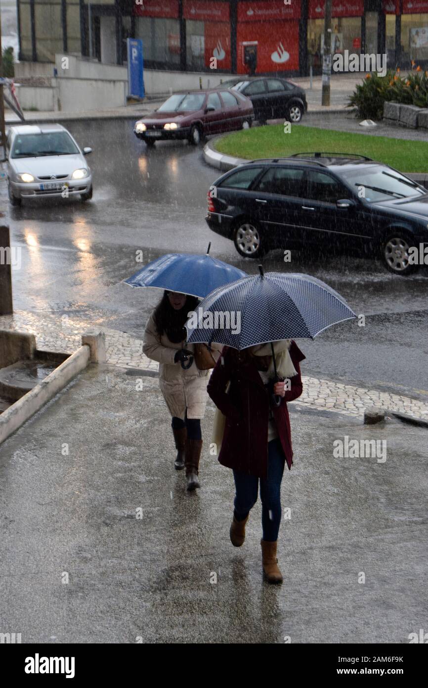 Les piétons essaient de rester au sec sous de fortes pluies à Coimbra Portugal Banque D'Images