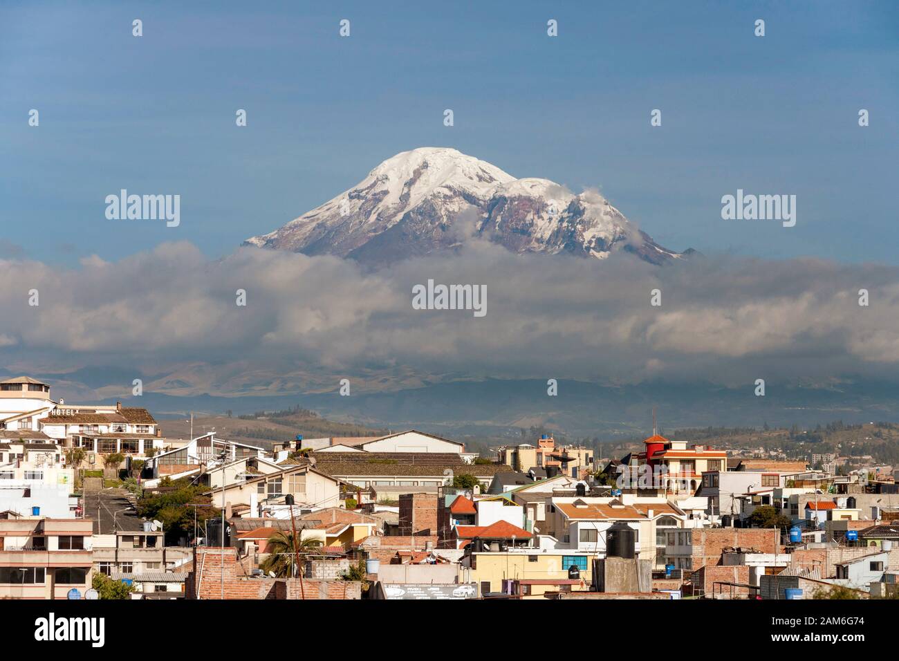 Mont Chimborazo volcan (6268 m) vu à travers les toits de la ville de Riobamba. Banque D'Images