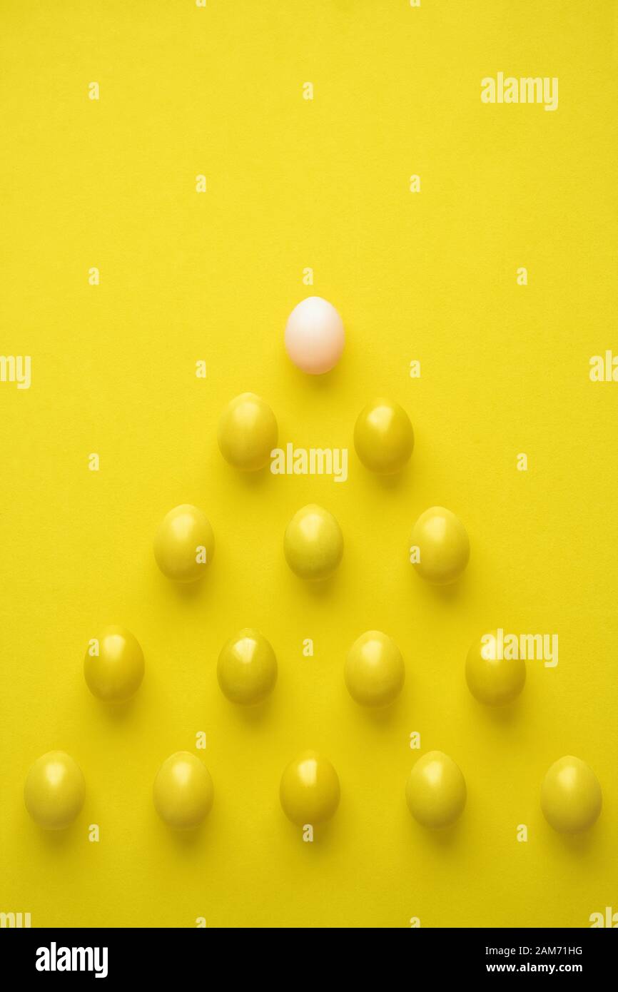 Plan des oeufs de poule en forme de pyramide contre fond jaune Banque D'Images