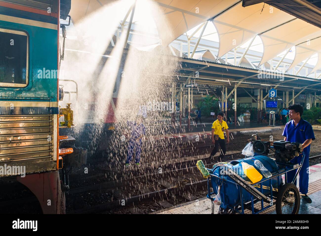 Bangkok/Thaïlande-décembre 2019: Équipe de nettoyage de la gare en salopette bleue au travail laver le train pour le départ avec jet d'eau à hua lamphong Banque D'Images