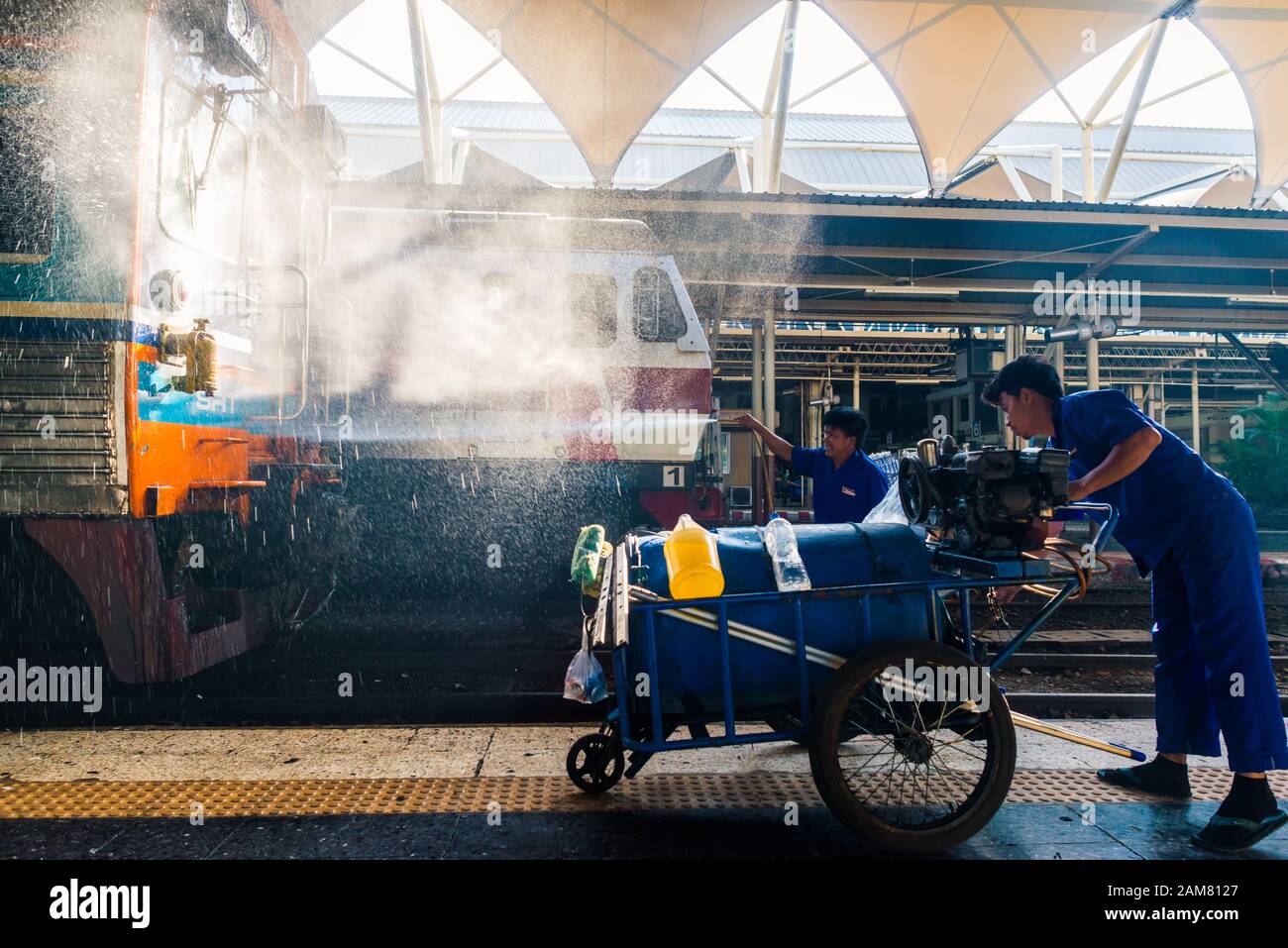 Bangkok/Thaïlande-décembre 2019: Équipe de nettoyage de la gare en salopette bleue au travail laver le train pour le départ avec jet d'eau à hua lamphong Banque D'Images