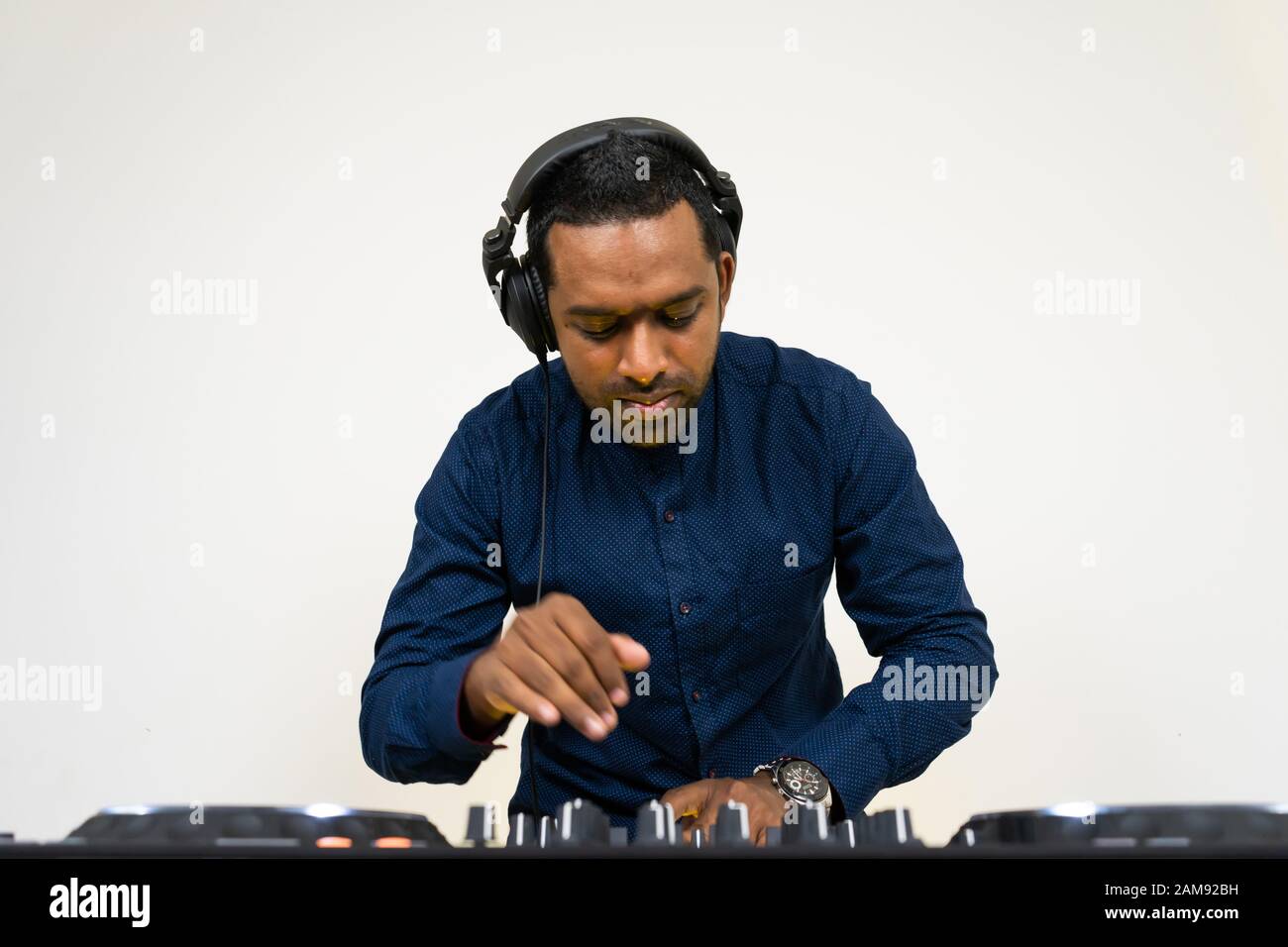 DJ mâle jouant de la musique sur fond blanc Banque D'Images
