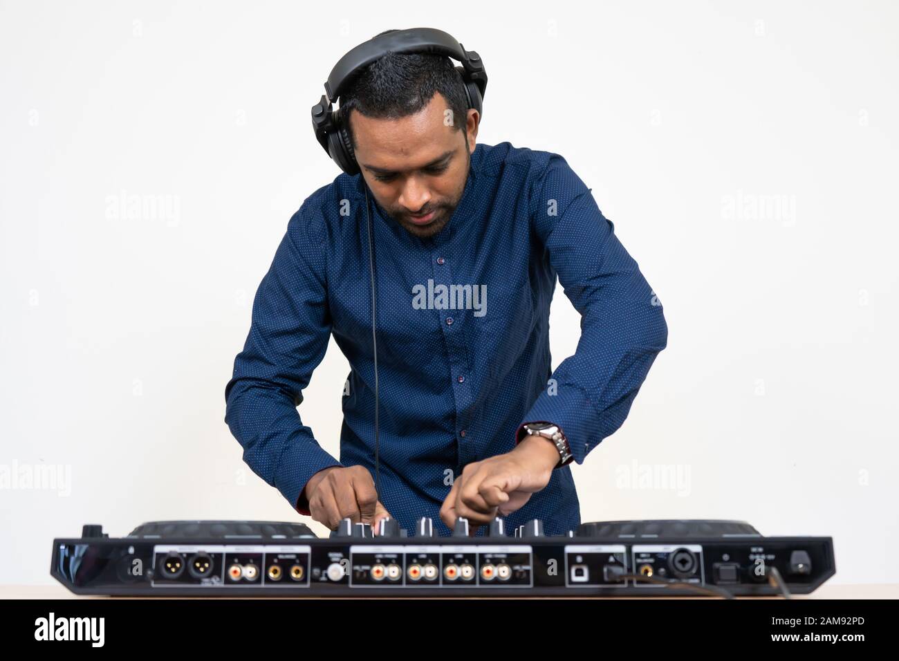 DJ mâle jouant de la musique sur fond blanc Banque D'Images