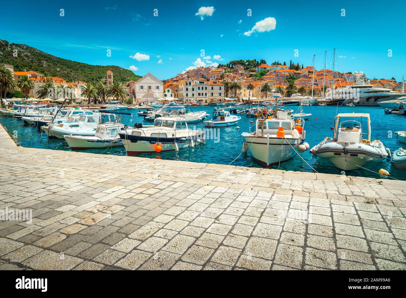 Station balnéaire méditerranéenne médiévale populaire avec beau port et majestueux paysage urbain. Yachts de luxe, bateaux à voile et bateaux de pêche ancrés à Hvar Banque D'Images