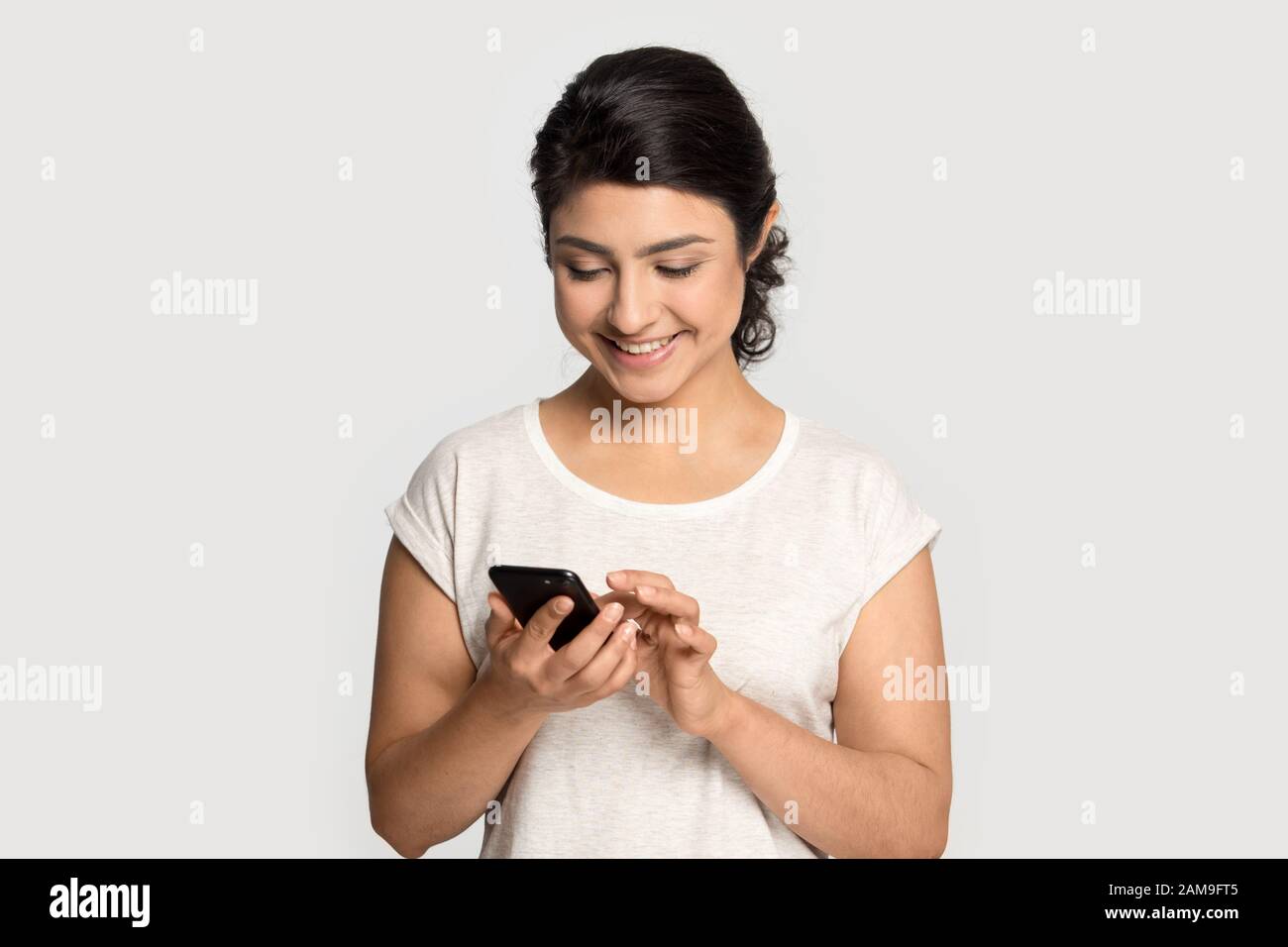 Une femme d'origine ethnique indienne du millénaire qui tient un téléphone cellulaire. Banque D'Images