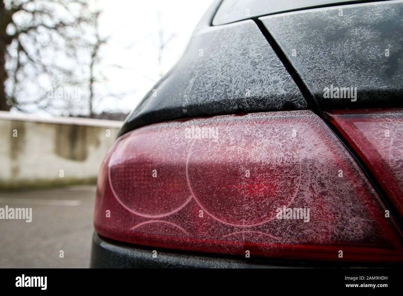 Le détail des feux arrière d'une voiture pendant la saison hivernale, sale avec des cartes du sel ou de la saumure utilisée contre la neige et la glace sur les routes. Banque D'Images