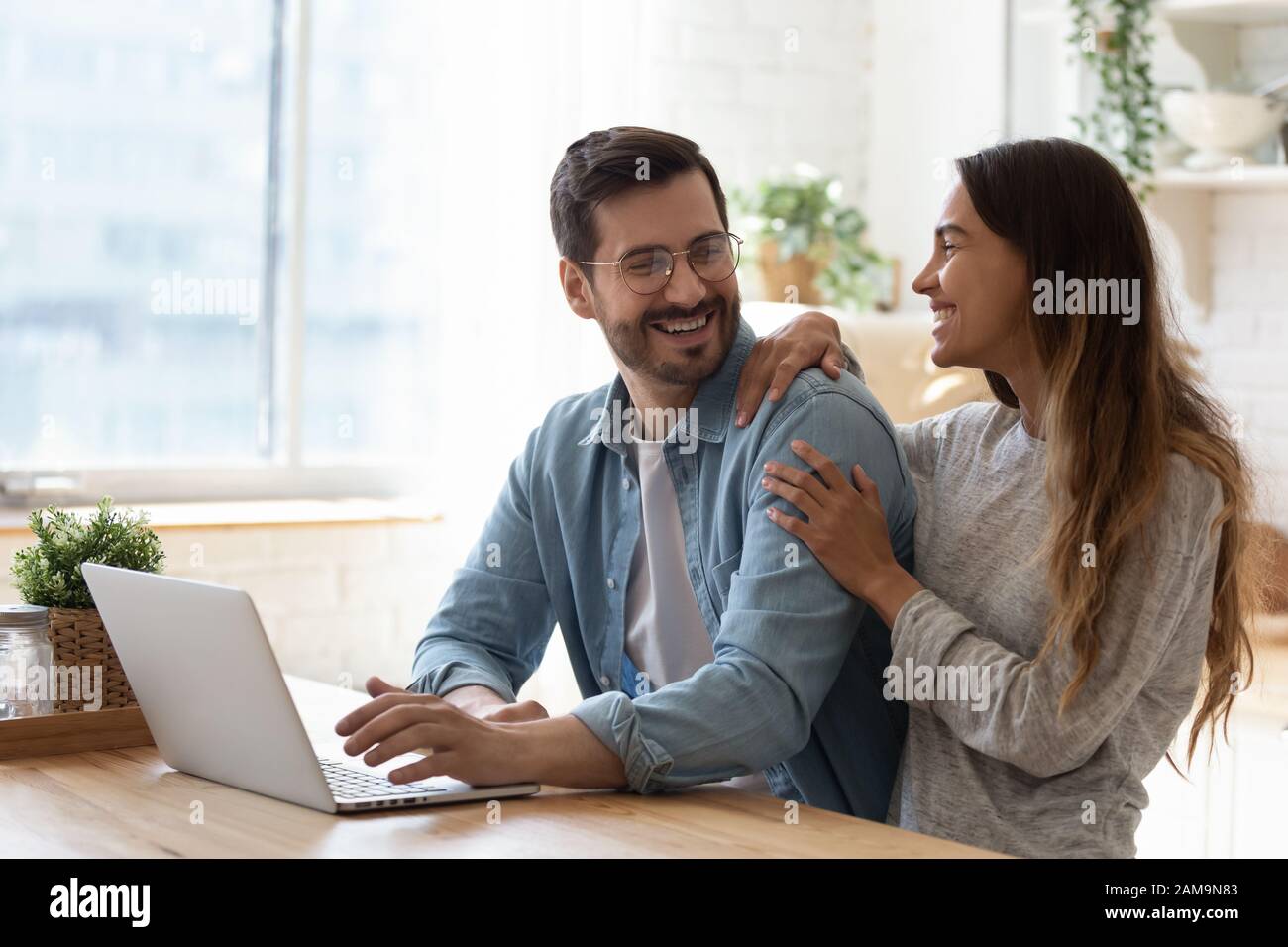 Un jeune homme heureux dans des lunettes regardant rire une femme. Banque D'Images