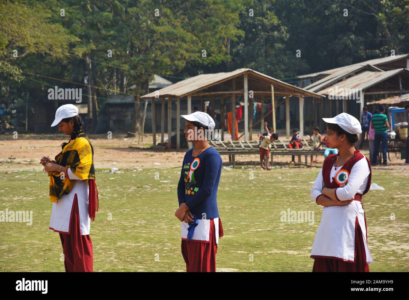 Chanda Bazar, Bongaon, Bengale occidental, Inde, 1 février, 2019 : trois filles de l'école en uniforme et casquette blanche et le bénévolat par lots Banque D'Images