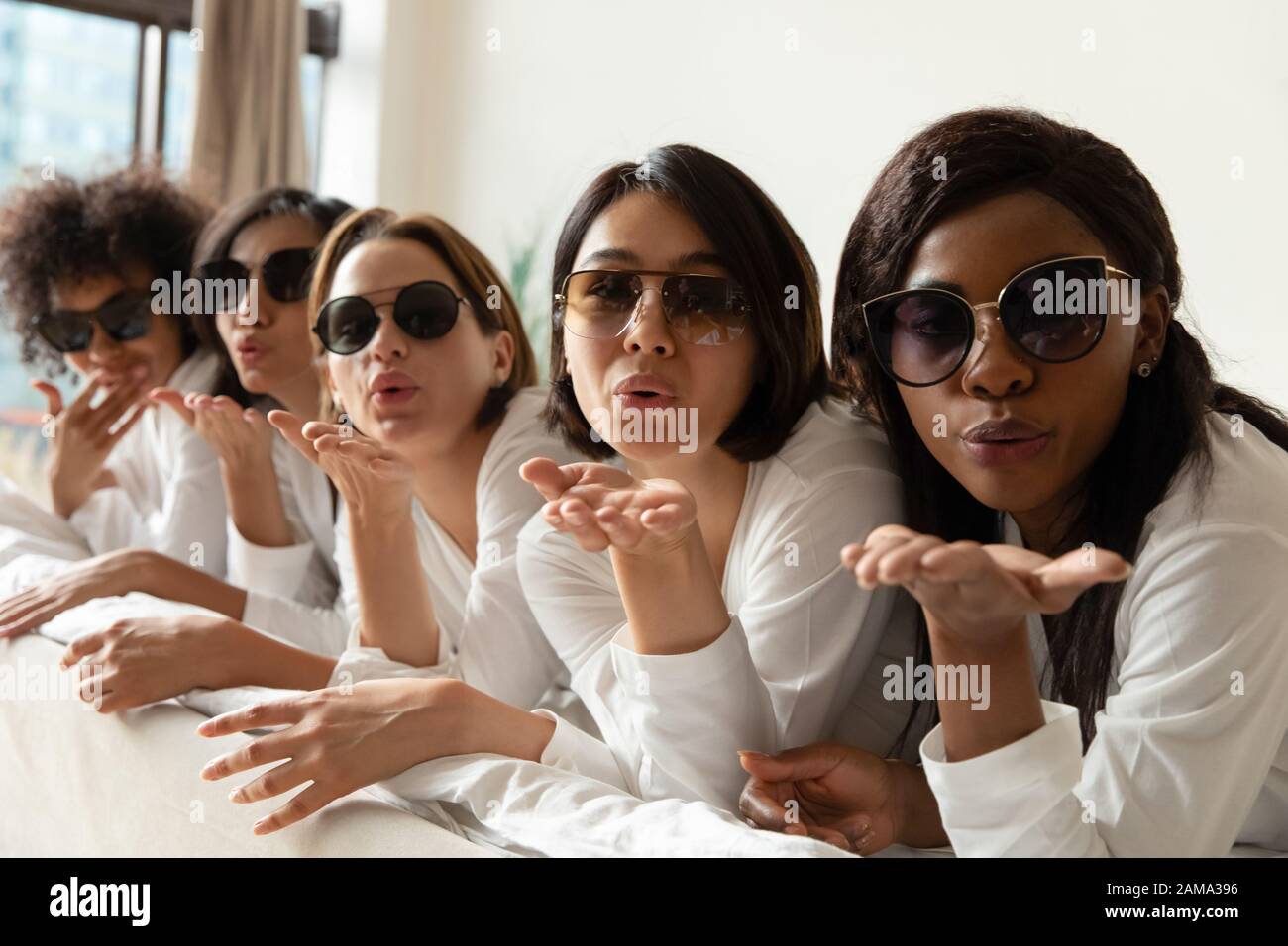 Filles multiraciales posant faire des photos à la fête de la poule Banque D'Images