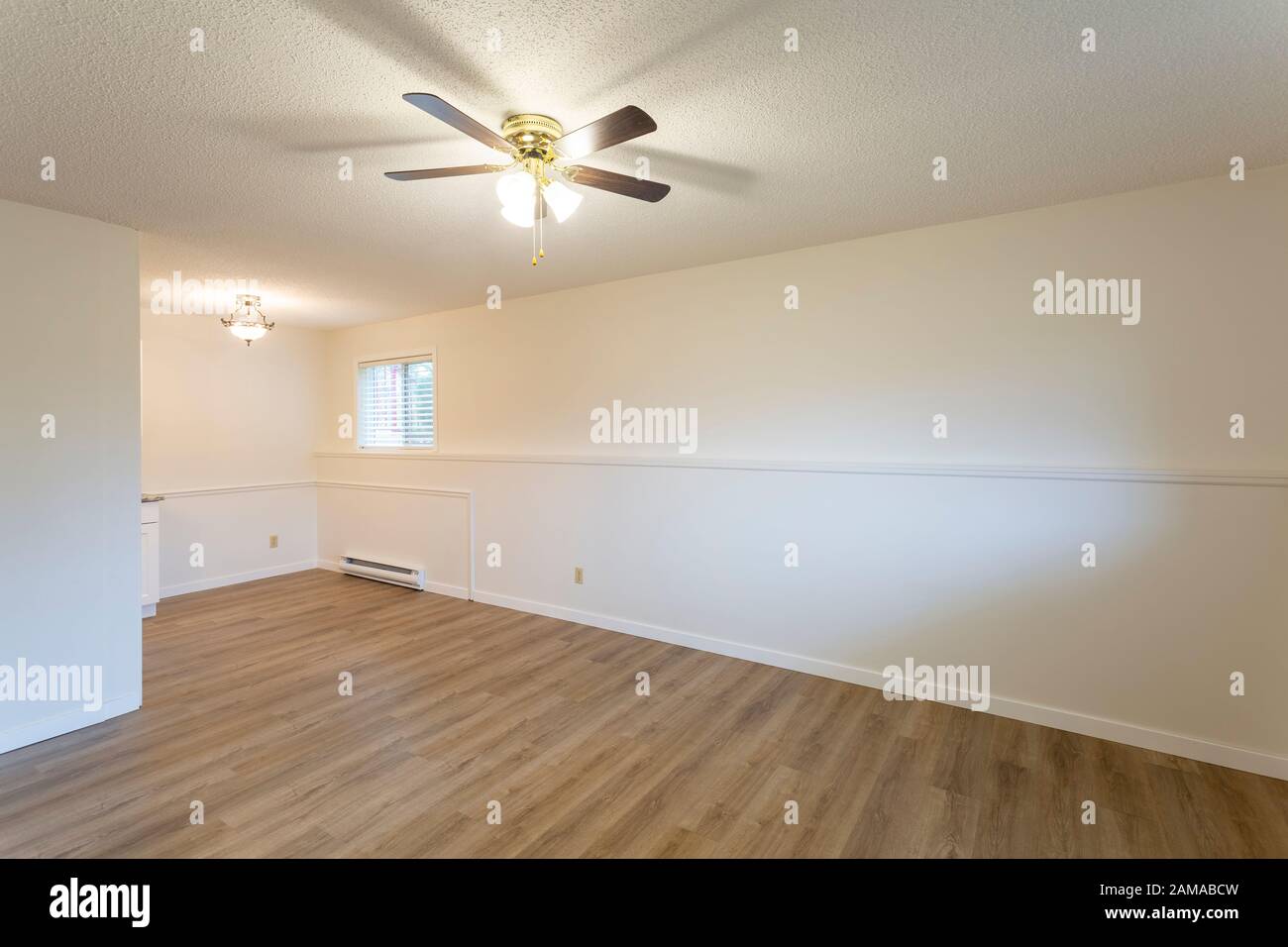 Intérieur de l'appartement vide rénové appartement appartement location unité avec murs blancs et nouveau parquet en vinyle dur stratifié. Banque D'Images