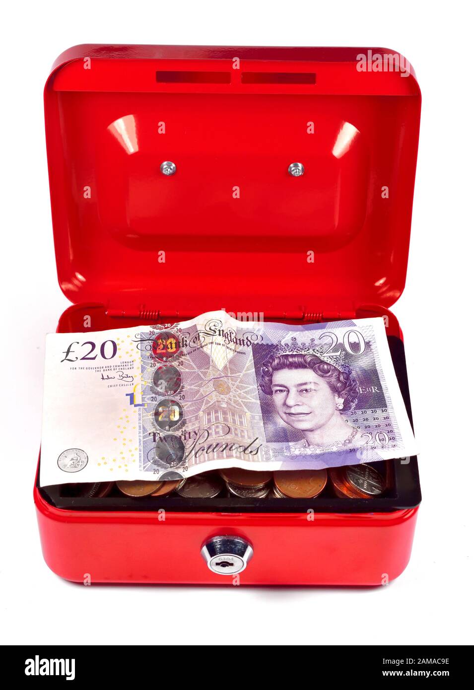 Boîte en argent rouge avec changement de pièce et une note de vingt livres sur un fond blanc Banque D'Images