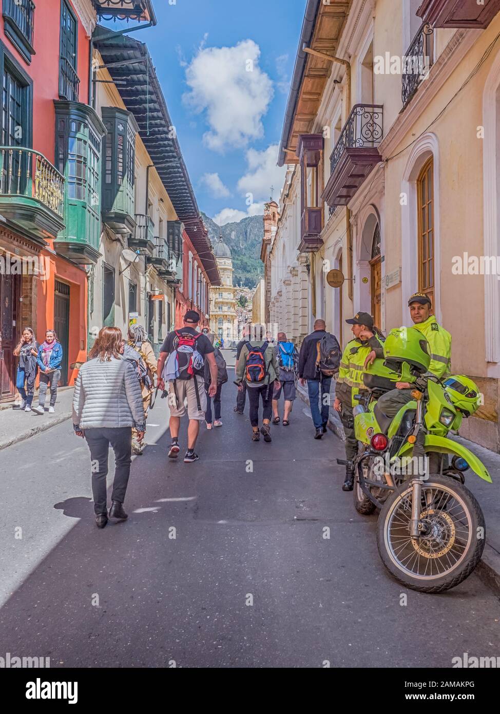 Bogota, Colombie - 12 septembre 2019: Rue de Bogota avec maisons coloniales colorées, foule du peuple, policier avec moto et montagne vi Banque D'Images