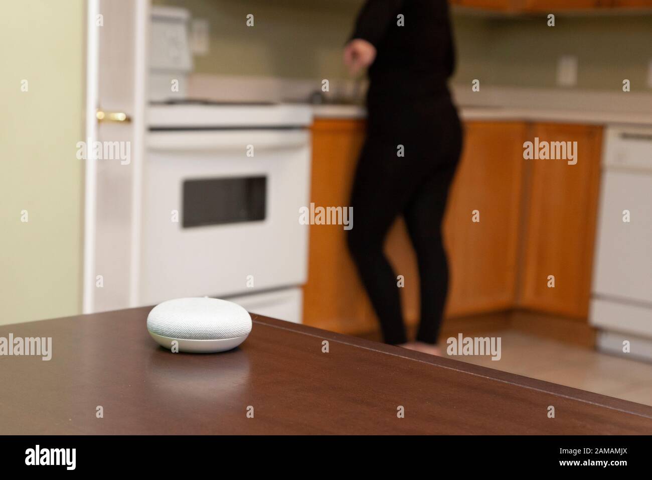 personne brouillée en arrière-plan pointant vers son appareil d'assistance intelligent pour haut-parleur domestique Banque D'Images