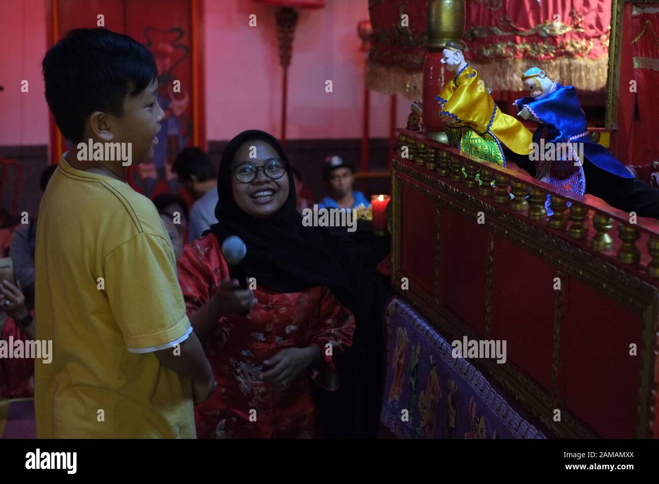 Un garçon et une femme musulmane devant un spectacle de marionnettes chinoises traditionnelles. Banque D'Images