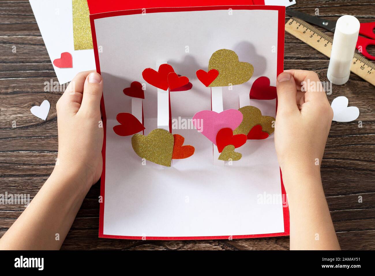 L'enfant tient une carte de vœux de Saint-Valentin ou un cadeau  d'anniversaire. Objets d'art pour enfants. Artisanat pour enfants Photo  Stock - Alamy