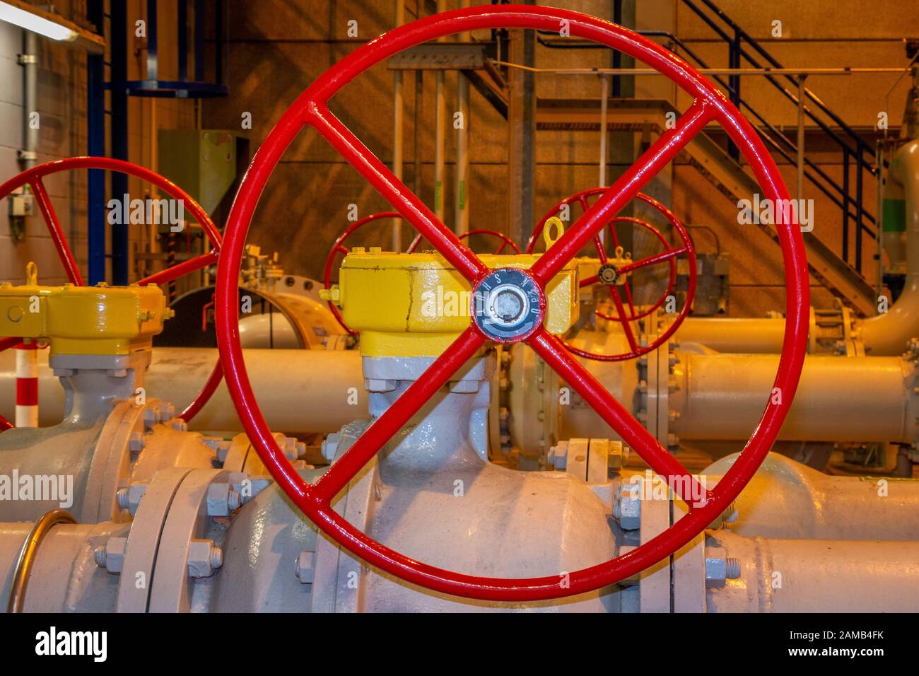 Roues manuelles peintes en rouge pour ouvrir ou fermer les vannes manuelles dans les tuyaux industriels Banque D'Images