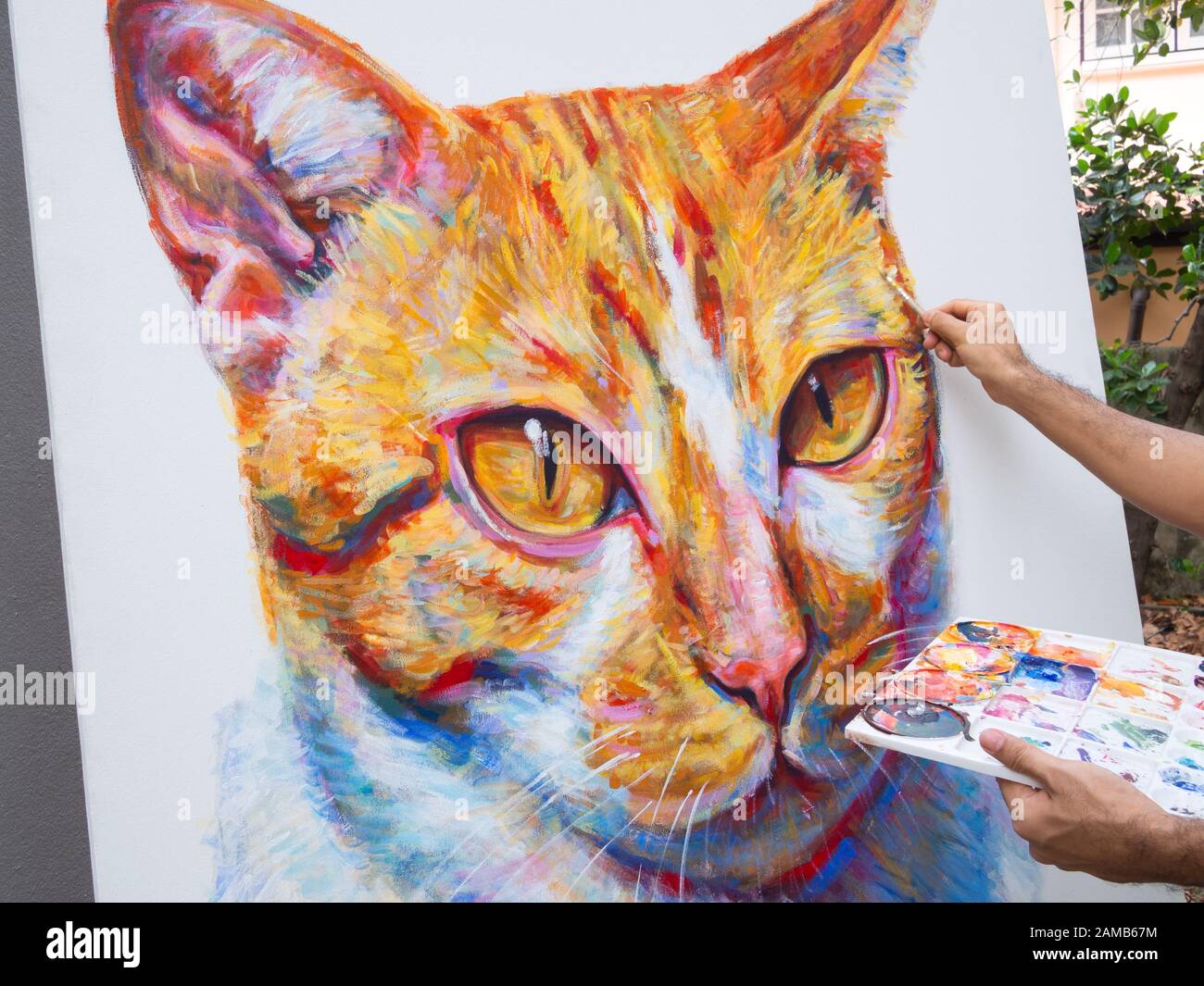 Gros plan artiste peinture portrait gingembre chat, couleur acrylique sur toile blanche. Banque D'Images