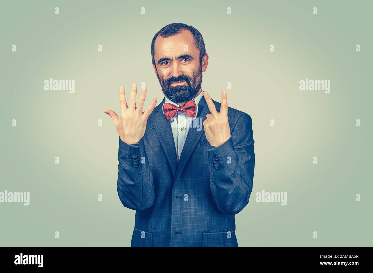 L'homme barbu montre un geste de sept doigts avec des mains isolées arrière-plan. Symbole de sensation d'expression faciale, langage corporel, communication non verbale. Scor Banque D'Images