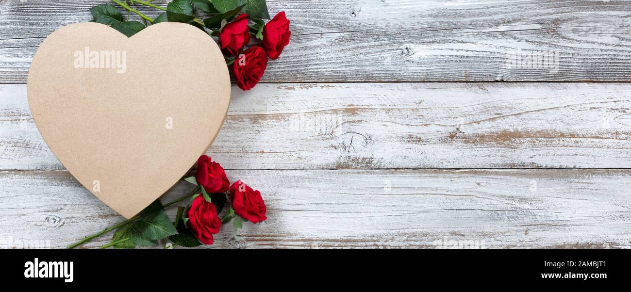 Bonne Saint Valentin avec une grande boîte cadeau en forme de coeur et de roses rouges Banque D'Images