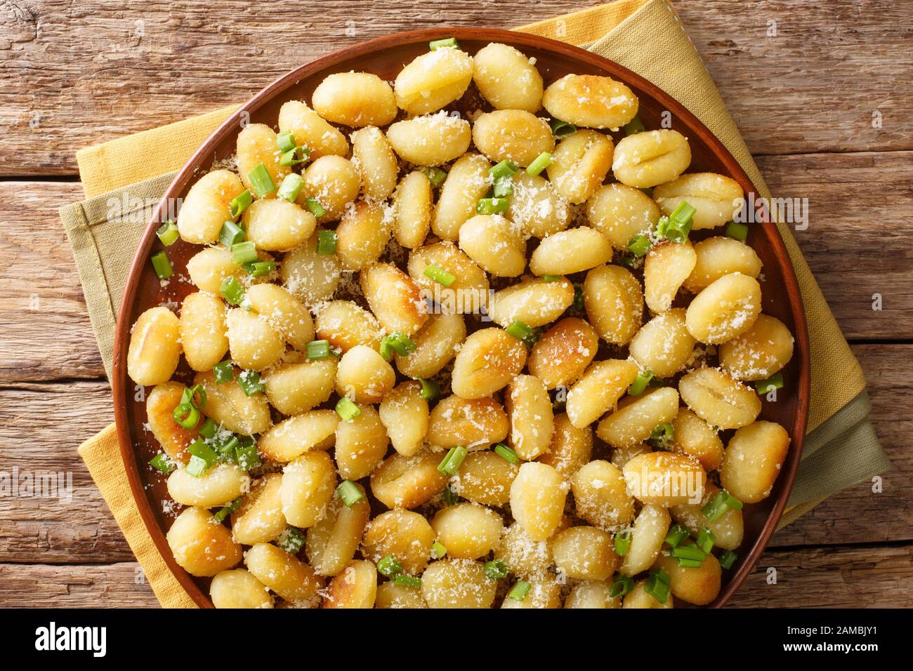 boulettes de pommes de terre sautées à l'huile gnocchi à l'ail, au fromage et aux oignons verts sur une plaque sur la table. Vue de dessus horizontale Banque D'Images