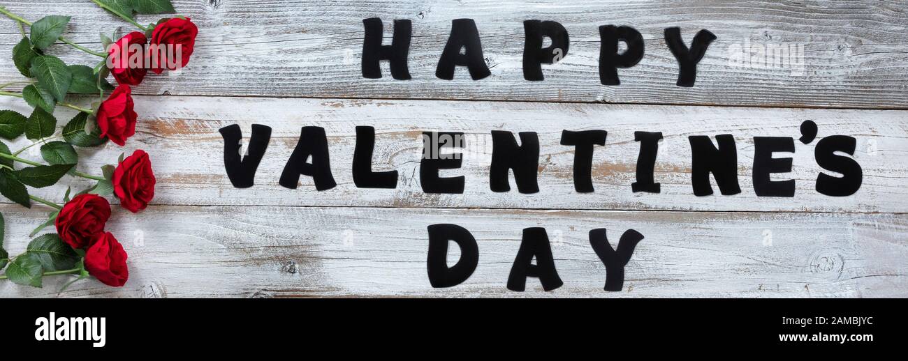 Bonne Saint Valentin avec de belles roses rouges et de grandes lettres de texte sur fond blanc rustique en bois Banque D'Images