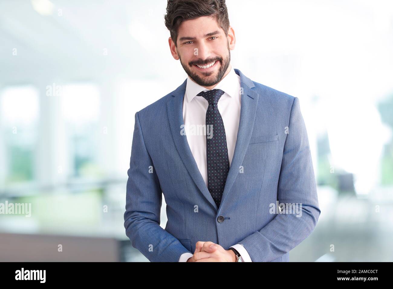 Portrait de jeune professionnel homme portant costume et cravate alors que  staning dans le bureau et en regardant la caméra Photo Stock - Alamy