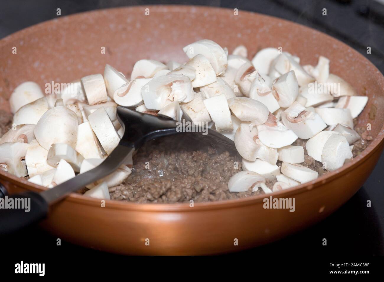 Bœuf haché haché doré et champignons dans la poêle à frire Banque D'Images