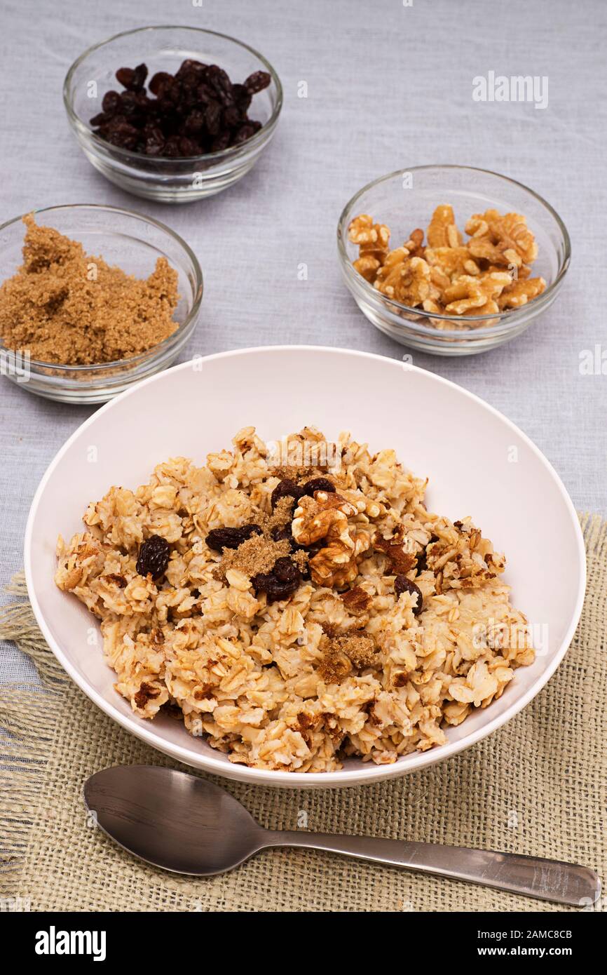 Petit déjeuner sain de flocons d'avoine chauds avec raisins secs, noix et sucre brun. Banque D'Images