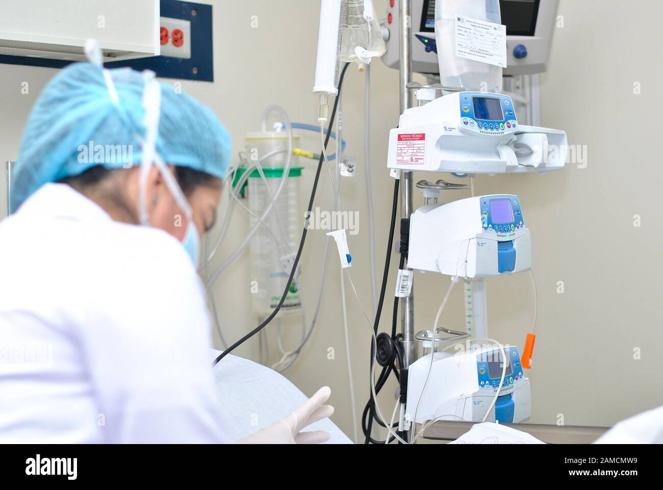 Une infirmière qui fréquente un patient, en arrière-plan, des pompes à perfusion. Hôpital Pédiatrique. Guayaquil. Équateur Banque D'Images