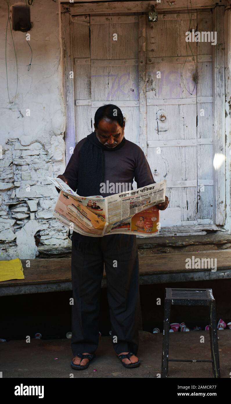 Un homme indien lisant le journal du matin à Pushkar, en Inde. Banque D'Images