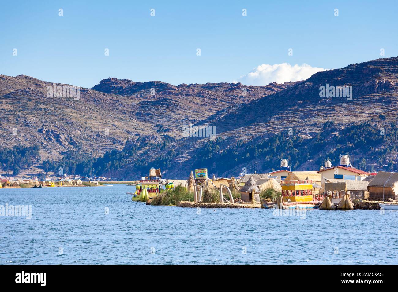 Îles Flottantes D'Uros, Lac Titicaca, Pérou, Amérique Du Sud - 2019-12-01. Vue sur l'île, un bateau des roseaux, ciel bleu dans les nuages Banque D'Images