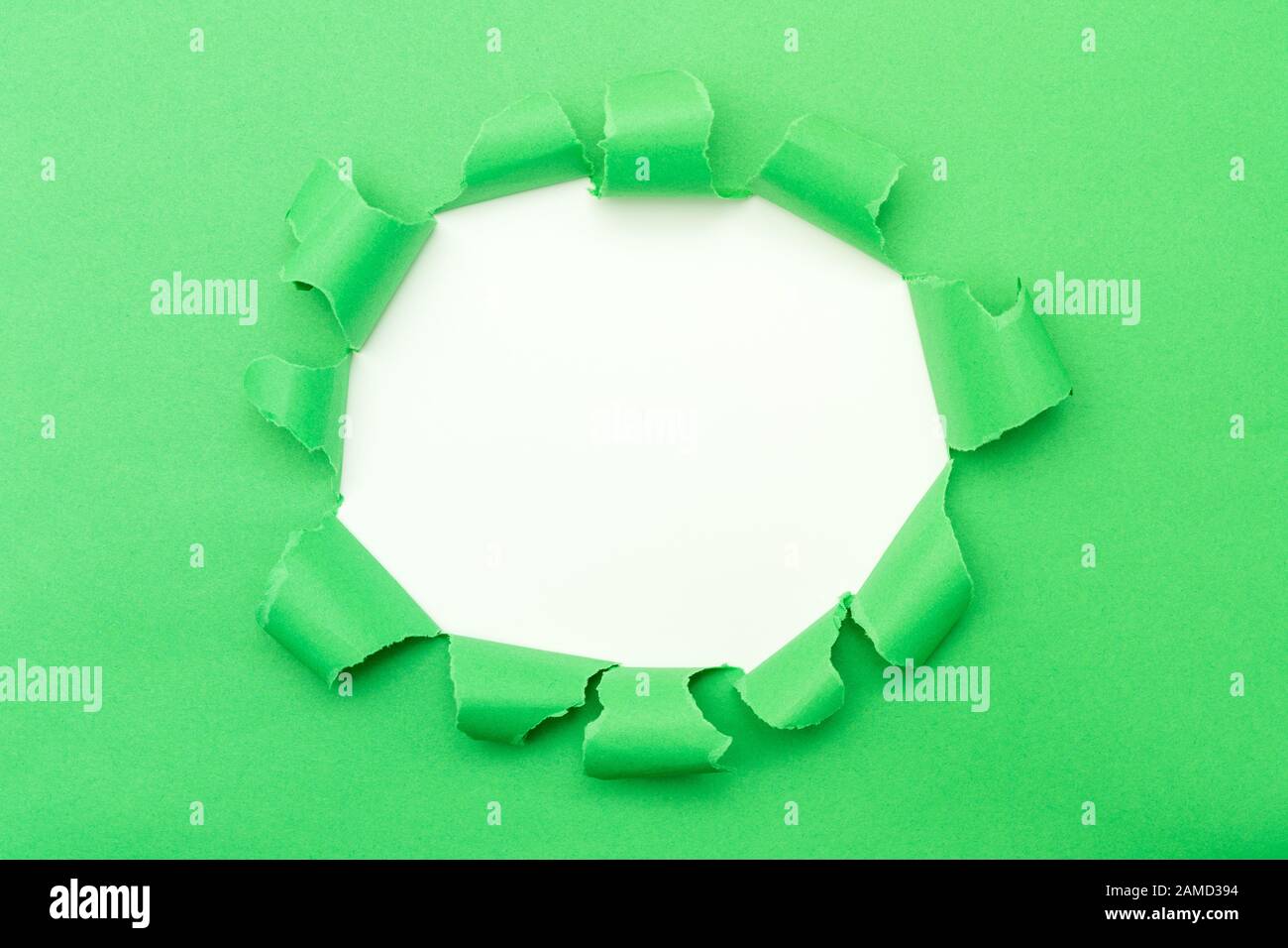 Papier vert avec trou déchiré dans l'arrière-plan central Banque D'Images