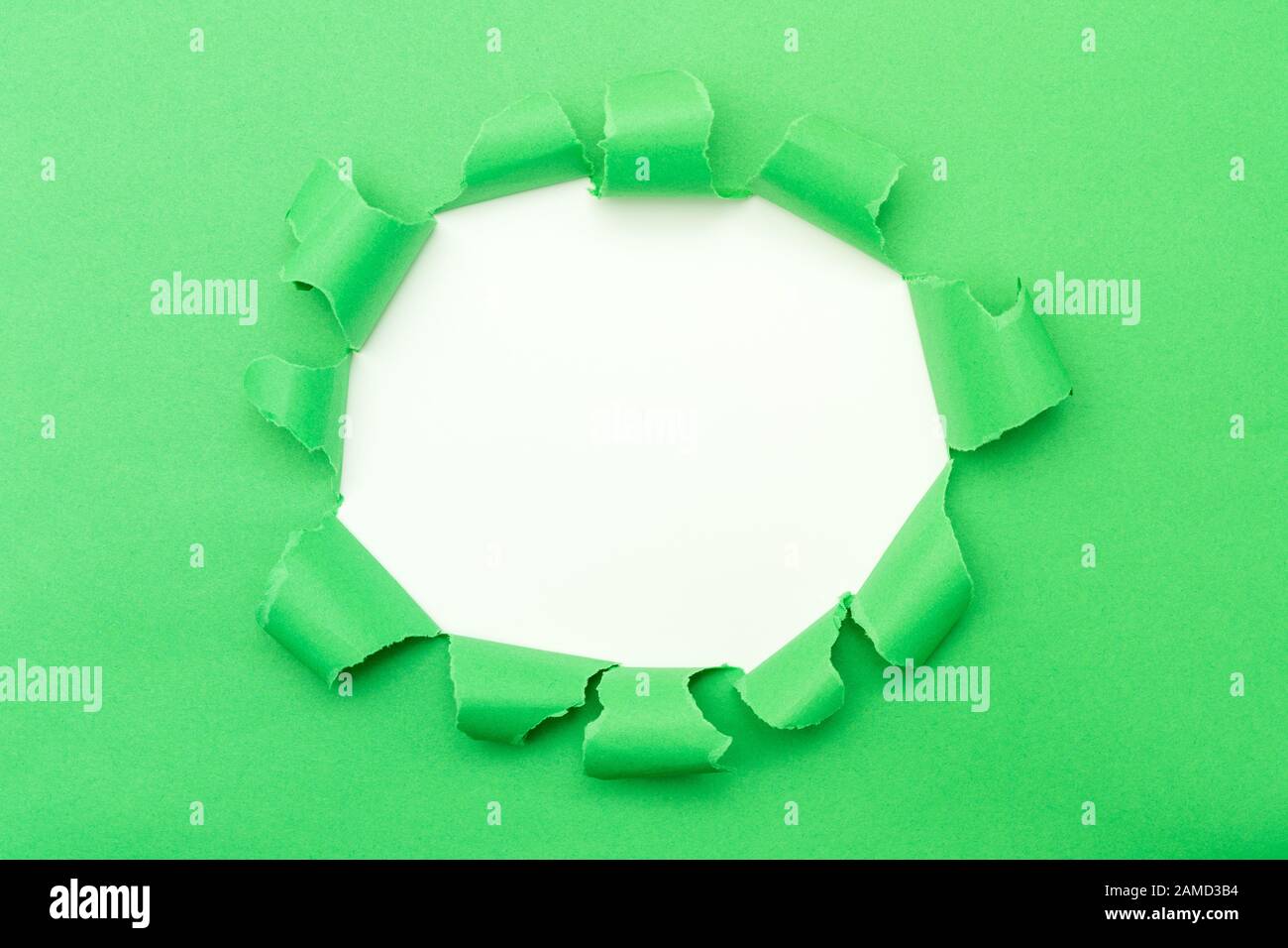 Papier vert avec trou déchiré dans l'arrière-plan central Banque D'Images