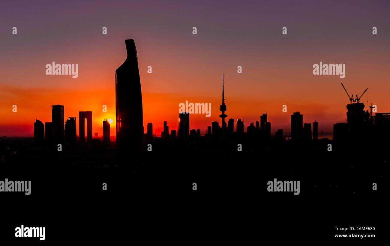 Coucher de soleil à Koweït City - Silhouttes de gratte-ciel et bâtiments Banque D'Images