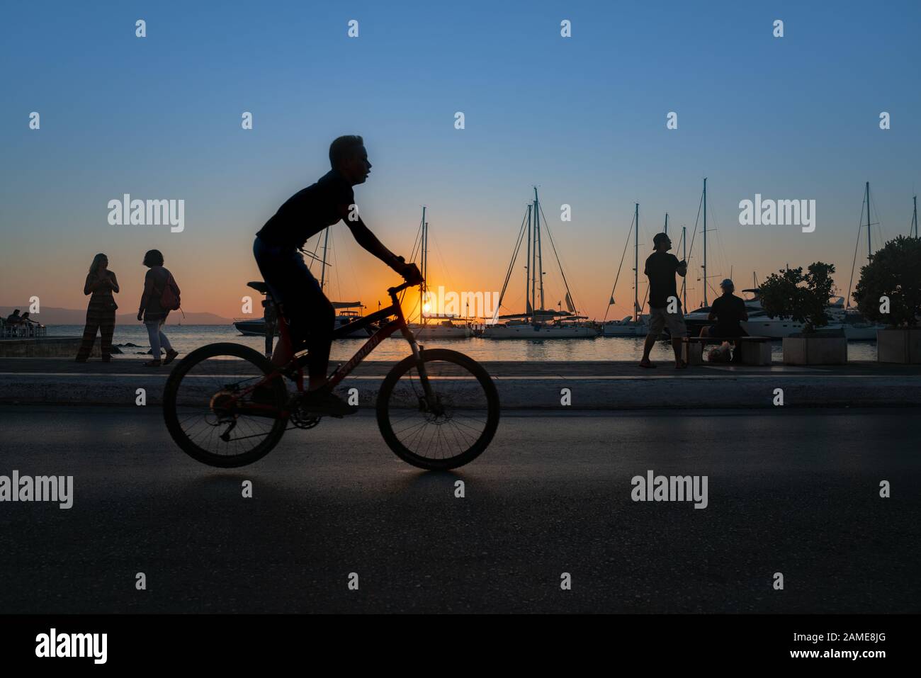 Naxos Grèce - 11 août 2019; en silhouette, un garçon passe à la fin de l'année passée à la recherche de la vue et des poissons locaux le matin sur la ville de Naxos wa Banque D'Images