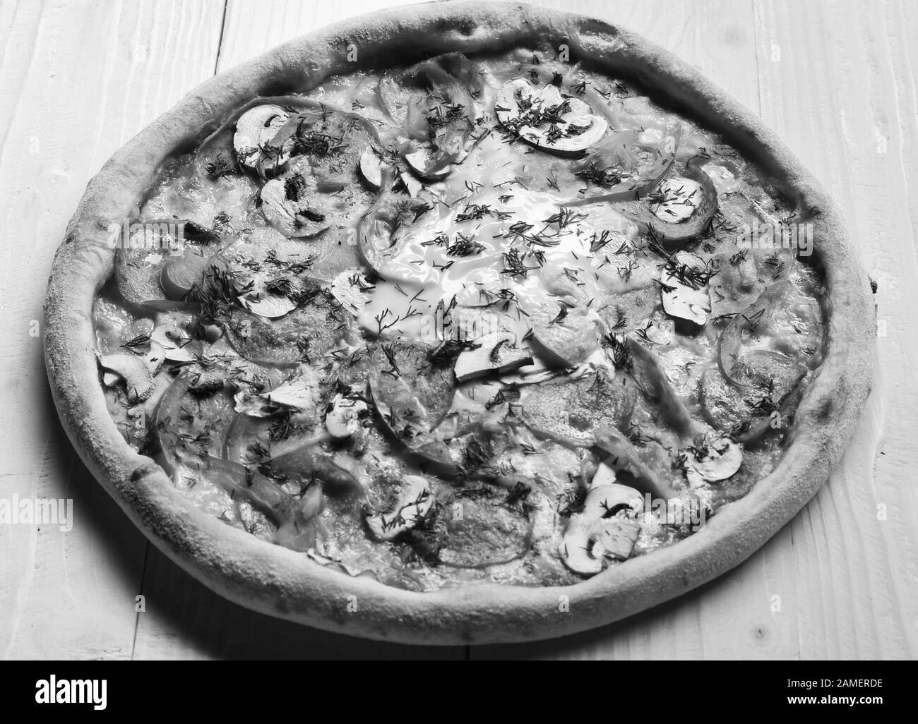 Livraison et cuisine italienne concept. Retirez les aliments avec de la sauce rouge et des bords croquants. Pizza épicée avec aneth et assaisonnement hachés. Pizza avec pepperoni, champignons et œufs sur fond en bois jaune. Banque D'Images