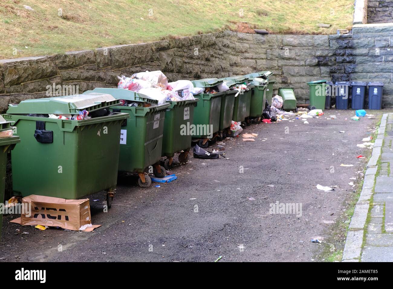 Plusieurs grandes poubelles à roues débordant de déchets en attente de collecte Banque D'Images
