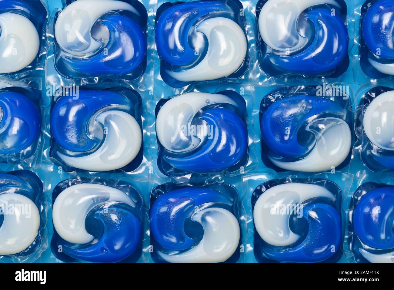 Gros plan sur les capsules/dosettes de lessive liquide pour lave-linge bleu  et blanc isolées sur un fond bleu Photo Stock - Alamy