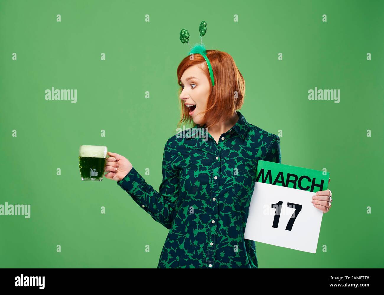 Une femme hurlant avec une tasse de bière et un calendrier complets Banque D'Images