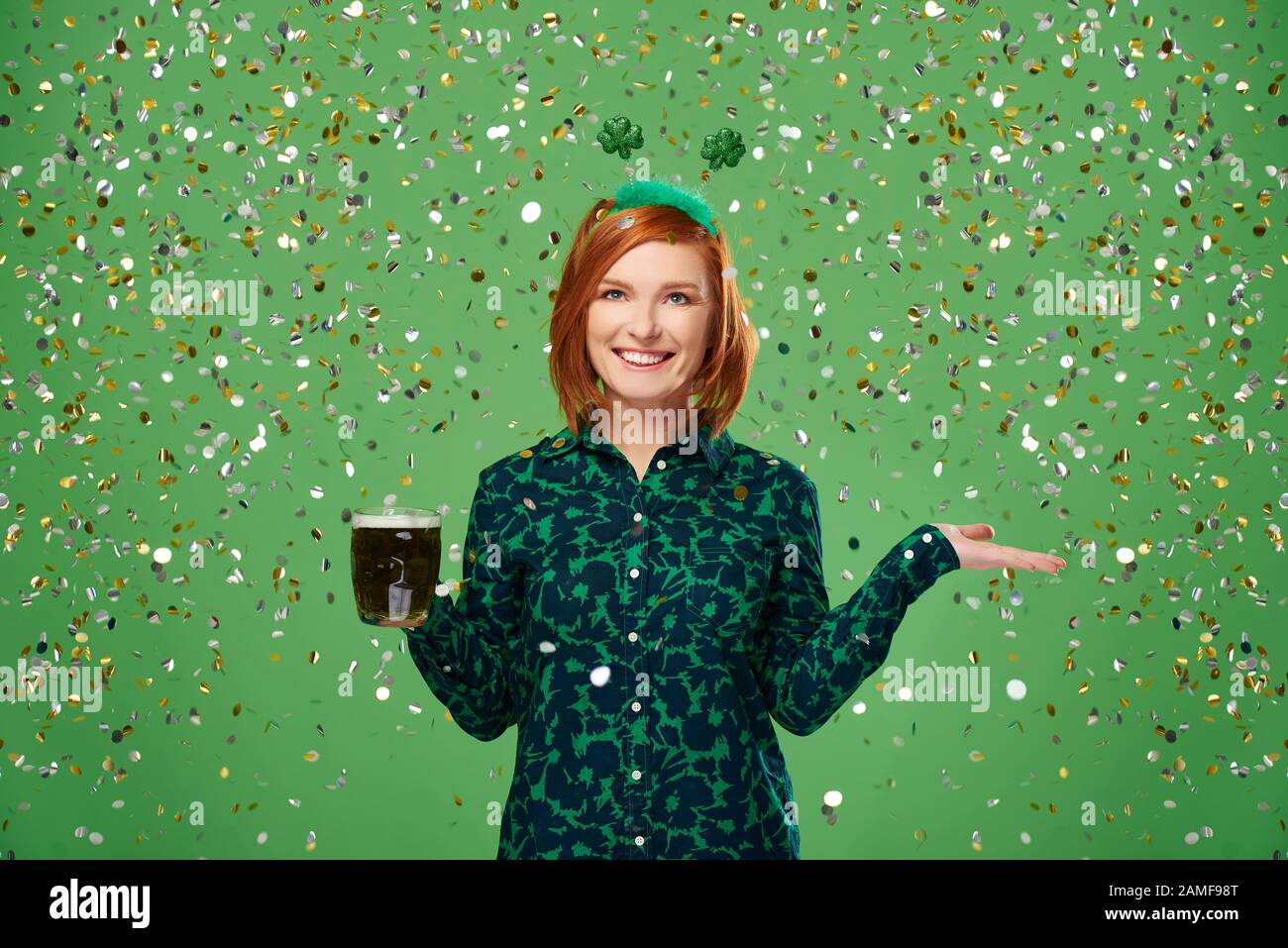 Portrait de femme avec bière sous une douche de confetti Banque D'Images