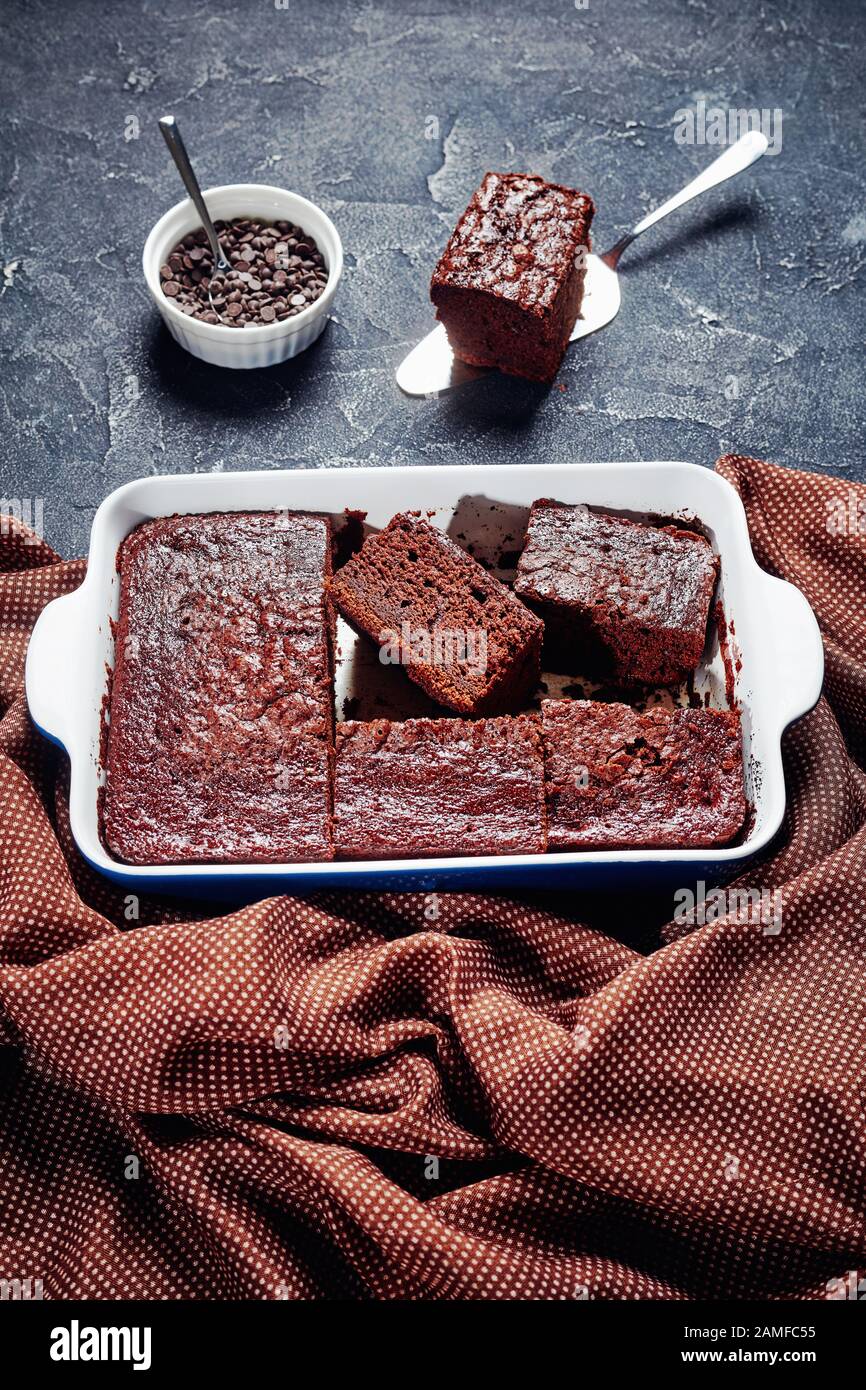 gros plan de délicieuses tranches de gâteau au chocolat maison fraîchement cuites dans un plat de cuisson sur une table en béton Banque D'Images