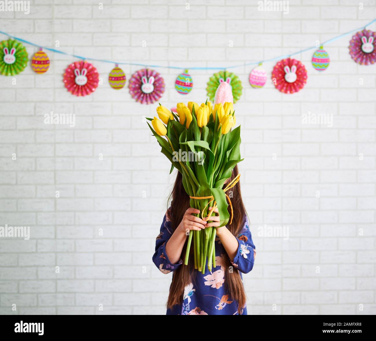 Fille tenant bande de tulipes devant son visage Banque D'Images