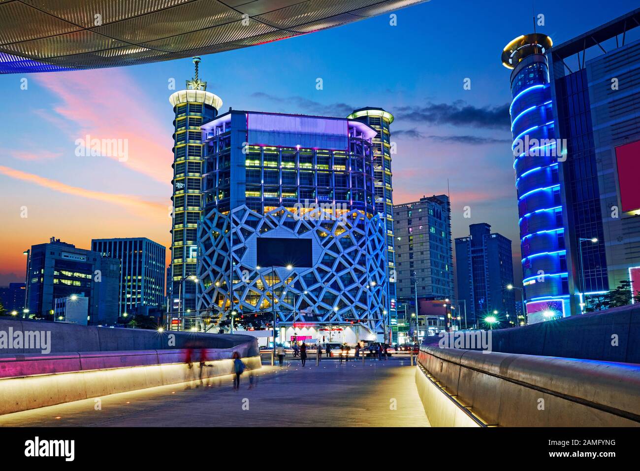 Le Dongdaemun Design plaza (conçu par Zaha Hadid) et le quartier des commerces de Séoul illuminés au crépuscule Banque D'Images