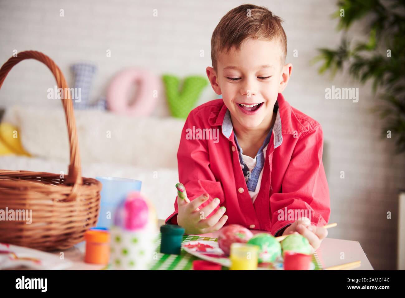 Joyeux garçon à peindre des œufs pour Pâques Banque D'Images