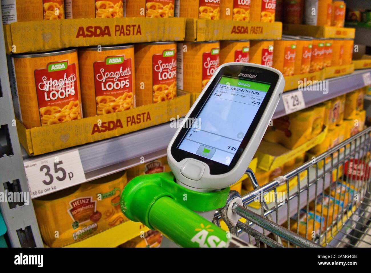 Un lecteur de codes à barres, pour une utilisation par le client, sur un support sur un chariot de supermarché dans un magasin ASDA au Royaume-Uni Banque D'Images