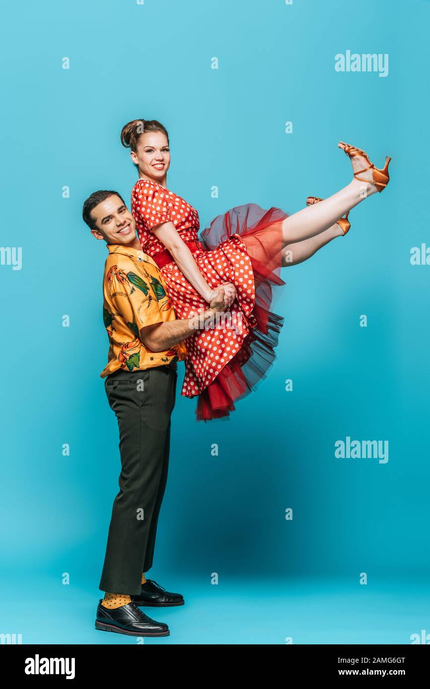 danseuse danseuse qui tient partenaire tout en dansant la boogie-woogie sur fond bleu Banque D'Images
